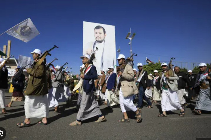 Các chiến binh Houthi mới được tuyển dụng diễu hành qua bức ảnh lớn của thủ lĩnh của họ, Abdul-Malik al-Houthi, vào tháng 12-2023 - Ảnh: EPA