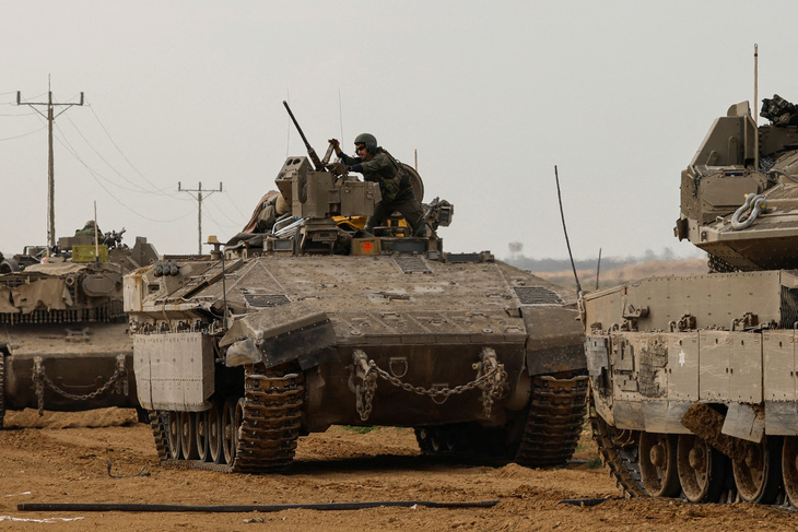 Binh sĩ Israel trên xe bọc thép chở quân khi họ từ Gaza quay trở lại Israel. Ảnh chụp gần biên giới Israel -  Gaza ở miền nam Israel vào ngày 11-1 - Ảnh: REUTERS