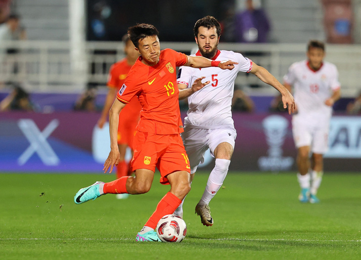 Tuyển Trung Quốc (áo đỏ) thi đấu mờ nhạt trước Tajikistan - Ảnh: REUTERS