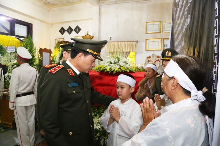 Trung ướng Lê Quốc Hùng - thứ trưởng Bộ Công an thăm hỏi, động viên gia đình trung tá Trần Duy Hùng hy sinh khi làm nhiệm vụ trấn áp tội phạm - Ảnh: TRẦN HỒNG