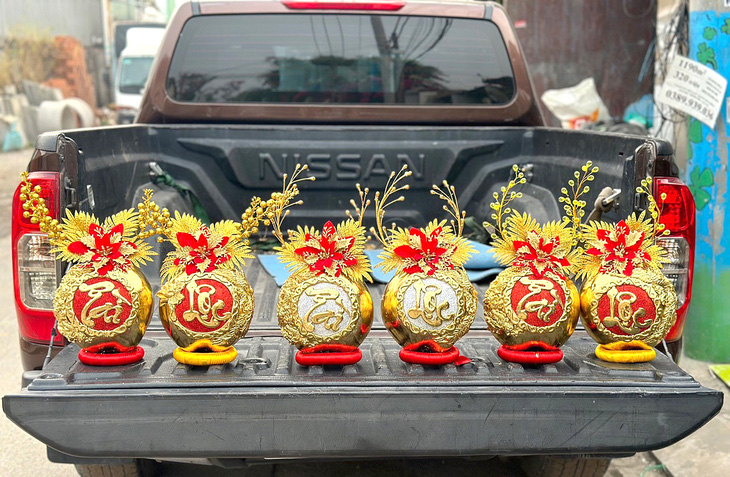 Trái dừa mạ vàng đắp chữ nổi được nhiều người ưa chuộng ở chợ Tết - Ảnh: N.Xuân