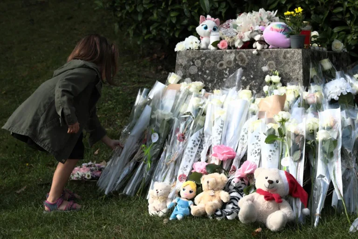 Mọi người đặt hoa và gấu bông tưởng niệm bé gái xấu số - Ảnh: LOU BENOIST