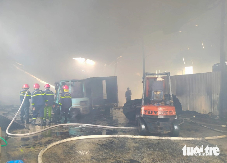 Mặc dù đám cháy đã được khống chế nhưng khói vẫn bốc nghi ngút gây khó khăn cho công tác cứu hộ - Ảnh: LÊ MINH
