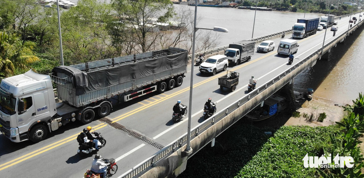 Một chiếc xe tải nặng qua cầu Rạch Miễu, dòng xe phải xếp hàng chậm chạp phía sau - Ảnh: MẬU TRƯỜNG 