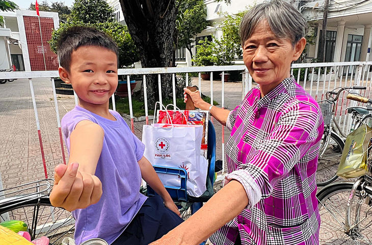 Hai bà cháu Huỳnh Thị Tuyết (65 tuổi) ngụ phường 10, quận 11 (TP.HCM) chở quà Tết về trong niềm vui - Ảnh: YẾN TRINH