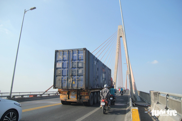 Một chiếc xe đầu kéo container ì ạch qua cầu Rạch Miễu. Theo thống kê, mỗi ngày có khoảng 2.000 xe tải nặng, xe 3 trục qua cầu này và những xe này là một trong những nguyên nhân gây kẹt xe - Ảnh: MẬU TRƯỜNG