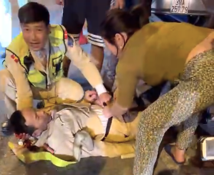 Thiếu tá Hồ Sỹ Tích bị tông ngã xuống đường, bị thương - Ảnh: Cắt từ Clip