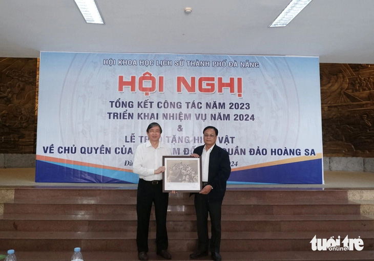 Ông Bùi Văn Tiếng, chủ tịch Hội Khoa học lịch sử Đà Nẵng (bên trái), trao tặng bức ảnh là tư liệu quý về Hoàng Sa cho ông Võ Ngọc Đồng, chủ tịch UBND huyện Hoàng Sa - Ảnh: TRƯỜNG TRUNG