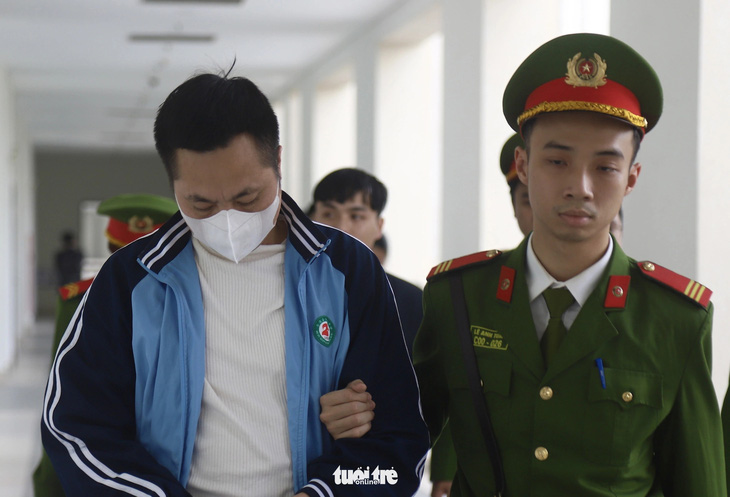 Bị cáo Bùi Đình Việt cúi mặt khi được dẫn giải đến tòa - Ảnh: DANH TRỌNG