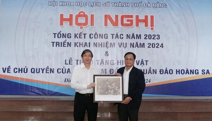 Ông Bùi Văn Tiếng, chủ tịch Hội Khoa học lịch sử Đà Nẵng (bên trái), trao tặng bức ảnh là tư liệu quý về Hoàng Sa cho ông Võ Ngọc Đồng, chủ tịch UBND huyện Hoàng Sa - Ảnh: TRƯỜNG TRUNG