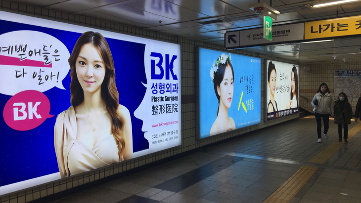 Quảng cáo phẫu thuật thẩm mỹ đặt sát nhau tại một ga tàu điện ngầm ở Seoul, Hàn Quốc - Ảnh: WAMU