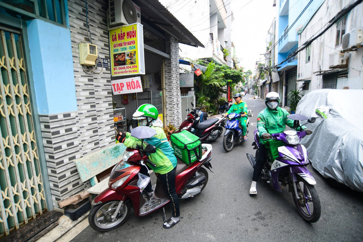 Shipper đến lấy đơn hàng tại quán gà hấp muối lá chanh A Sơn, chi nhánh trong hẻm đường Nguyễn Thái Bình (quận Tân Bình, TP.HCM) - Ảnh: QUANG ĐỊNH