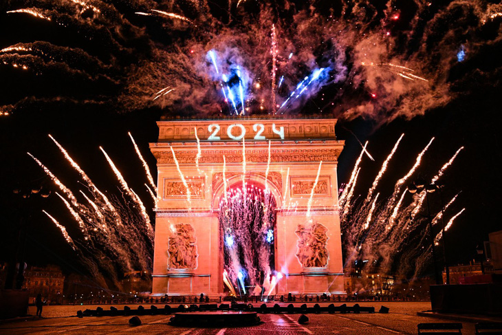 Pháo hoa thắp sáng Khải Hoàn Môn ở Paris, Pháp, chào đón năm 2024 - Ảnh: AFP