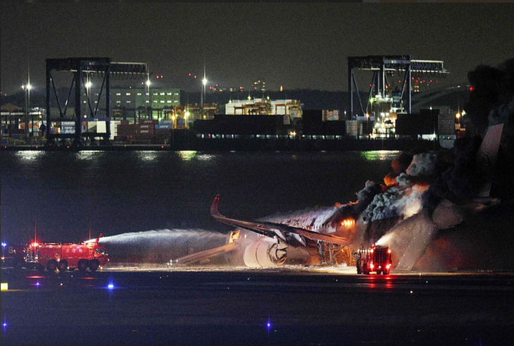 Xe cứu hỏa dập lửa bao trùm chiếc máy bay chở khách bốc cháy ở sân bay Haneda, Nhật Bản, ngày 2-1 - Ảnh: AFP