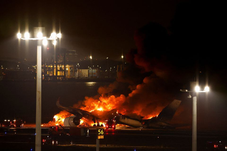 Lính cứu hỏa dập lửa tại sân bay quốc tế Haneda (Tokyo, Nhật Bản) ngày 2-1, sau khi chiếc máy bay A350 của Hãng Japan Airlines bốc cháy - Ảnh: REUTERS