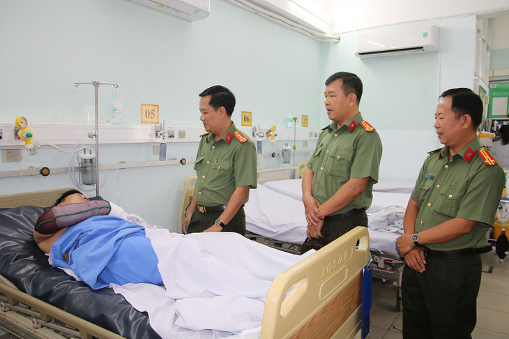 Lãnh đạo Công an tỉnh An Giang thăm, động viên thiếu tá bị chém khi trấn áp kẻ cầm dao chém bừa bãi ngoài đường - Ảnh: MAI PHƯƠNG
