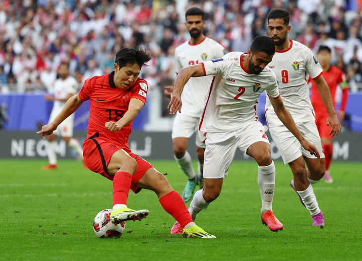Lee Kang In (áo đỏ) tranh chấp bóng với cầu thủ Jordan - Ảnh: REUTERS