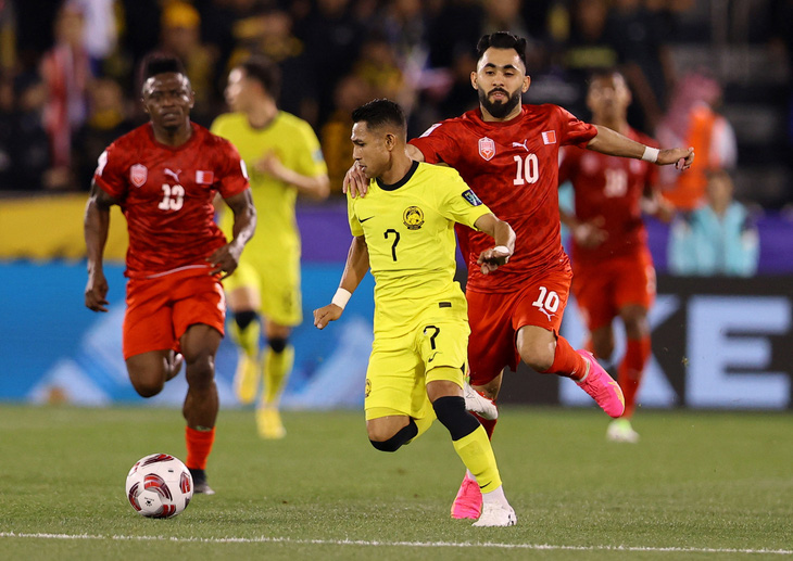 Tiền vệ Faisal Halim (áo vàng) tranh chấp bóng quyết liệt với cầu thủ Bahrain - Ảnh: REUTERS