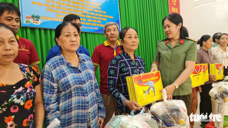 Thượng tá Nguyễn Thị Thanh Thương, phó trưởng Phòng an ninh chính trị nội bộ Công an tỉnh Bến Tre, trao quà cho bà con có hoàn cảnh khó khăn - Ảnh: MẬU TRƯỜNG