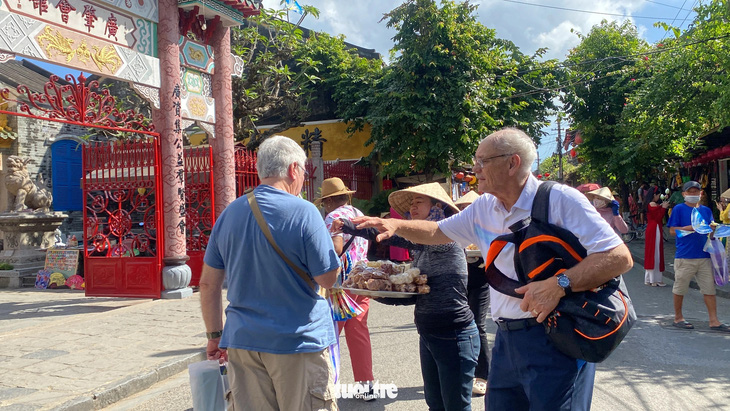 Thấy bạn mình bị hàng rong chèo kéo, làm phiền nên người khách đi cùng phải kéo vai 