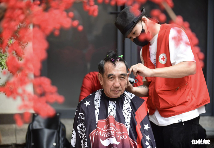 Dịch vụ cắt tóc miễn phí cũng đông khách từ sáng đến trưa. Ông Lê Văn Phước, 68 tuổi, an tâm cắt tóc chờ mọi người đi mua sắm.