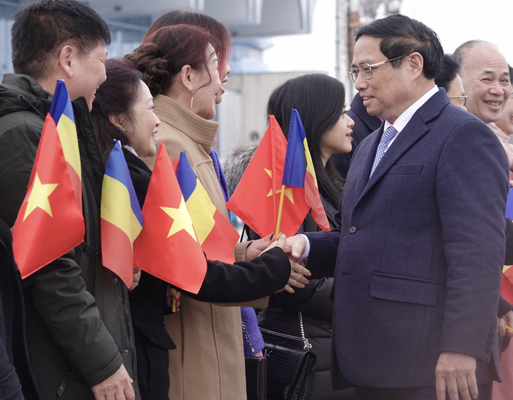 Thủ tướng Phạm Minh Chính bắt tay cán bộ Đại sứ quán Việt Nam và kiều bào tại sân bay ở Bucharest - Ảnh: QUỲNH TRUNG