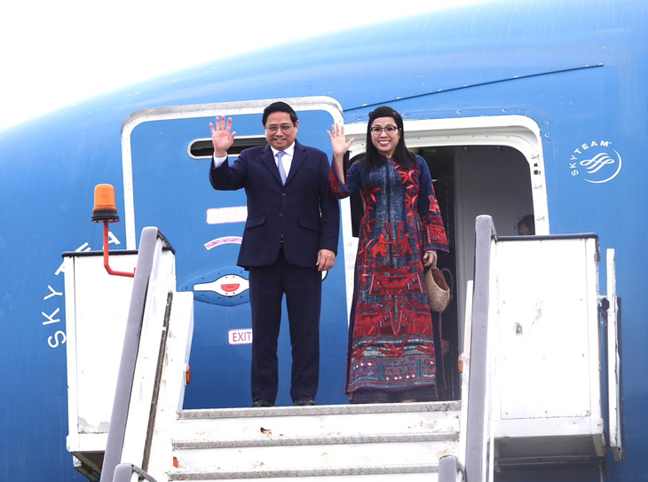 Thủ tướng Phạm Minh Chính và phu nhân vẫy chào khi đến sân bay Bucharest, bắt đầu chuyến thăm chính thức Romania chiều 20-1 giờ địa phương - Ảnh: QUỲNH TRUNG