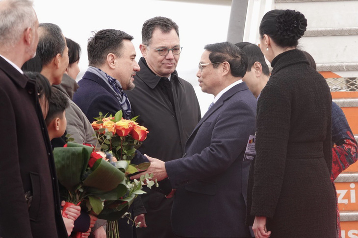 Các quan chức Romania đón Thủ tướng Phạm Minh Chính tại chân cầu thang máy bay - Ảnh: QUỲNH TRUNG