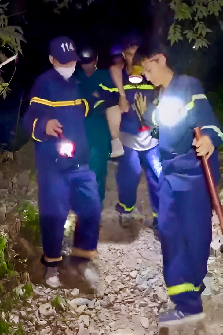 Lực lượng cứu hộ đưa một nạn nhân kẹt trên núi Cô Tiên xuống núi - Ảnh cắt từ clip