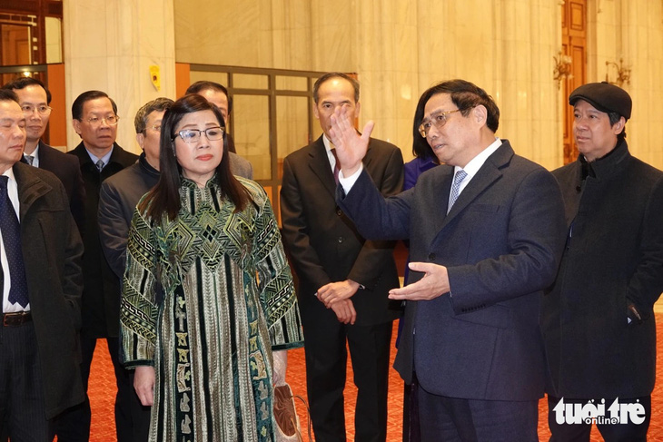 Thủ tướng Phạm Minh Chính thuyết minh về lịch sử tòa nhà Quốc hội Romania cho phu nhân và các thành viên trong đoàn - Ảnh: QUỲNH TRUNG