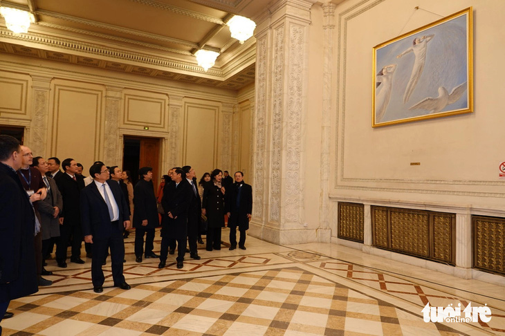 Thủ tướng Phạm Minh Chính và đoàn đại biểu Việt Nam thưởng thức một tác phẩm nghệ thuật bên trong tòa nhà Quốc hội Romania - Ảnh: QUỲNH TRUNG