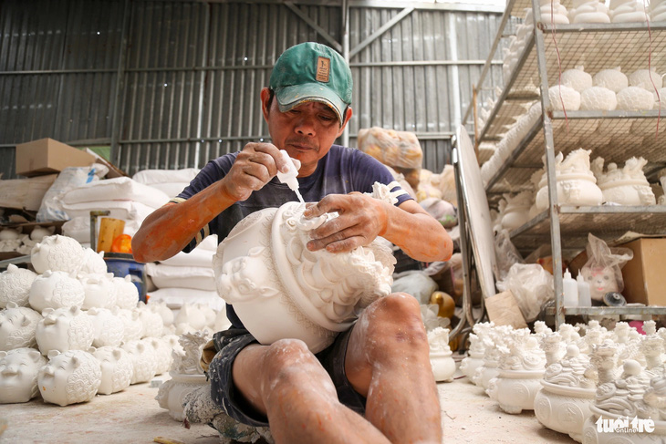 Ngoài làm heo truyền thống, nhiều xưởng còn kết hợp làm heo mạ vàng bằng thạch cao vừa trưng trong ngày Tết vừa kết hợp bỏ ống với ngụ ý may mắn, tài lộc - Ảnh: P.Q