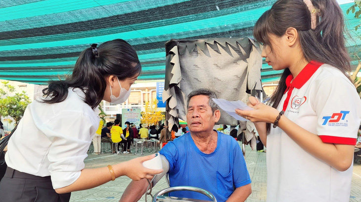 Chiến sĩ Xuân tình nguyện hỗ trợ thăm khám sức khỏe cho ông Nguyễn Văn Cường (69 tuổi) ở huyện Nhà Bè (TP.HCM) - Ảnh: C.TRIỆU