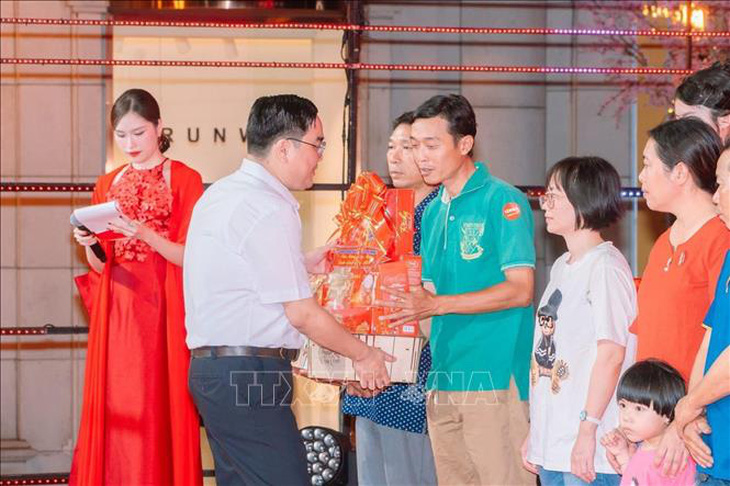 Anh Ngô Minh Hải, Phó Bí thư Thường trực Thành đoàn, Chủ tịch Hội Liên hiệp Thanh niên Việt Nam TP.HCM (áo trắng) trao quà cho các gia đình thanh niên công nhân - Ảnh: TTXVN