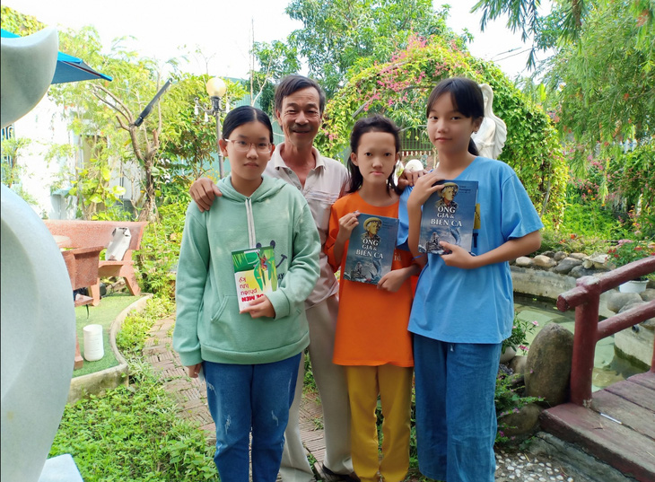 Thầy Phạm Đình Thành tặng sách cho các em học sinh học tốt, thi tốt môn Văn - Ảnh: NVCC