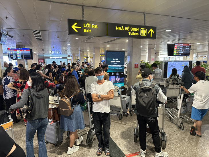 Khu vực băng chuyền hành lý ga quốc nội Tân Sơn Nhất đông nghẹt khách. Có thời điểm ùn tắc, trả hành lý chậm hơn so với quy định - Ảnh: CÔNG TRUNG