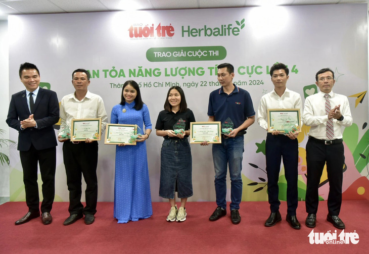 Giám đốc truyền thông Herbalife Việt Nam Nguyễn Thành Đạt (bìa trái) và Phó tổng biên tập báo Tuổi Trẻ Trần Xuân Toàn (bìa phải) trao giải nhất, nhì, ba cho các tác giả đoạt giải - Ảnh: T.T.D.