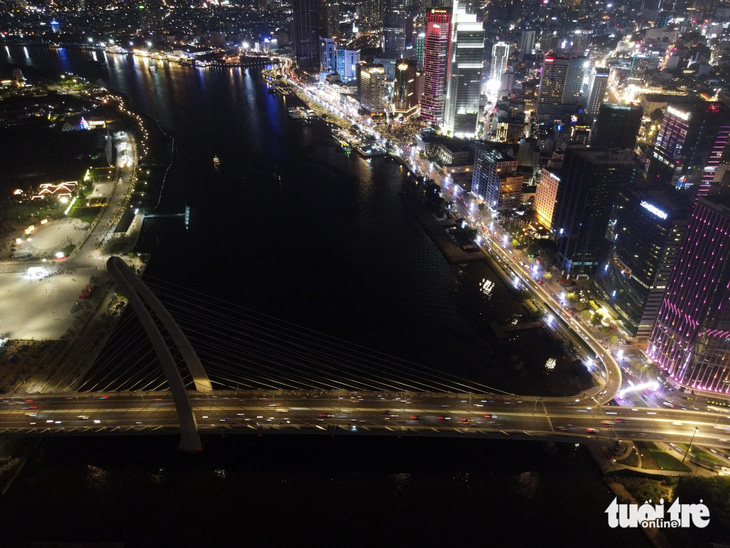 Cầu Ba Son lu mờ giữa bao ánh đèn điện sáng rực đôi bờ sông Sài Gòn đoạn qua trung tâm TP.HCM - Ảnh: CHÂU TUẤN