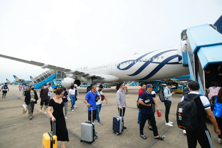 Đi lại dịp Tết, hành khách thường mang nhiều hành lý xách tay và ký gửi. Trong ảnh: Khách lên máy bay của Vietnam Airlines tại Tân Sơn Nhất - Ảnh: QUANG ĐỊNH