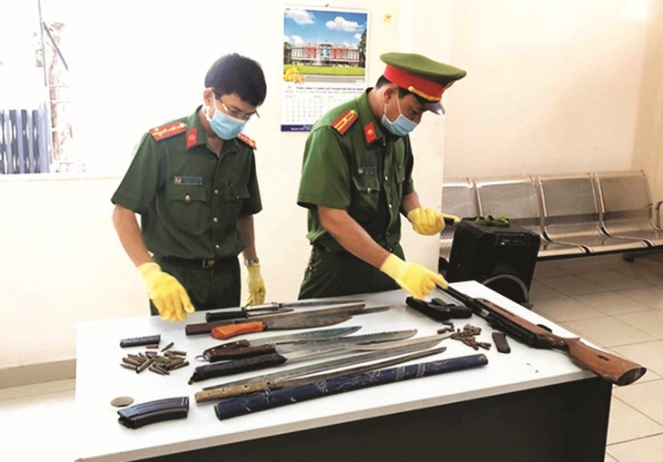 Người dân giao nộp nhiều vũ khí, trong đó có các loại dao, kiếm cho lực lượng công an - Ảnh: Báo CAND