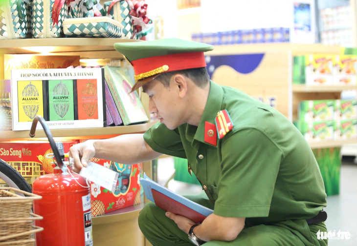 Trung tá Lê Tấn Châu kiểm tra bình chữa cháy được đặt trong khu vực nhà chờ lên tàu bay - Ảnh: MINH HÒA
