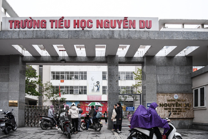 Cổng Trường tiểu học Nguyễn Du, Hà Nội đầu giờ sáng 23-1. Vẫn có phụ huynh cho con tới trường và các trường vẫn mở cửa đón học sinh - Ảnh: NAM TRẦN
