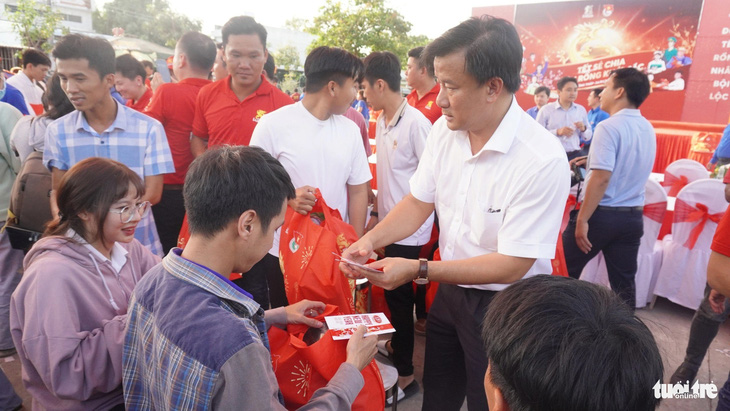 Ông Nguyễn Phước Thiện - phó chủ tịch UBND tỉnh Đồng Tháp (áo trắng) - trao quà và tiền mặt cho công nhân lao động có hoàn cảnh khó khăn - Ảnh: ĐẶNG TUYẾT