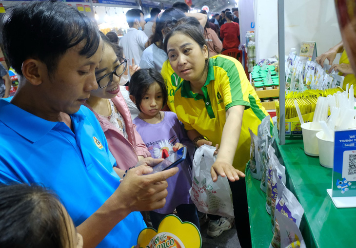 Công nhân quét mã QR mua sắm ở Phiên chợ nghĩa tình tổ chức tại quận Bình Tân (TP.HCM) sẽ kéo dài đến 27-1 - Ảnh: VŨ THỦY