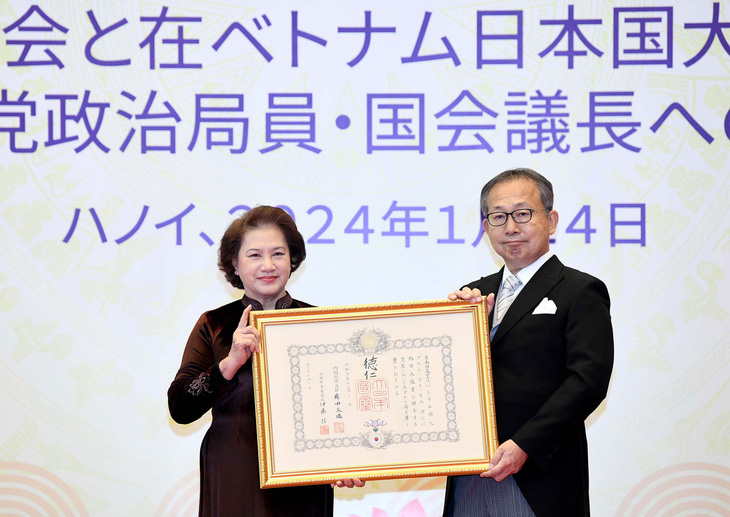 Đại sứ đặc mệnh toàn quyền Nhật Bản tại Việt Nam Yamada Takio đã công bố quyết định tặng huân chương, gắn huân chương và trao hoa cho nguyên Chủ tịch Quốc hội Nguyễn Thị Kim Ngân - Ảnh: PHẠM THẮNG