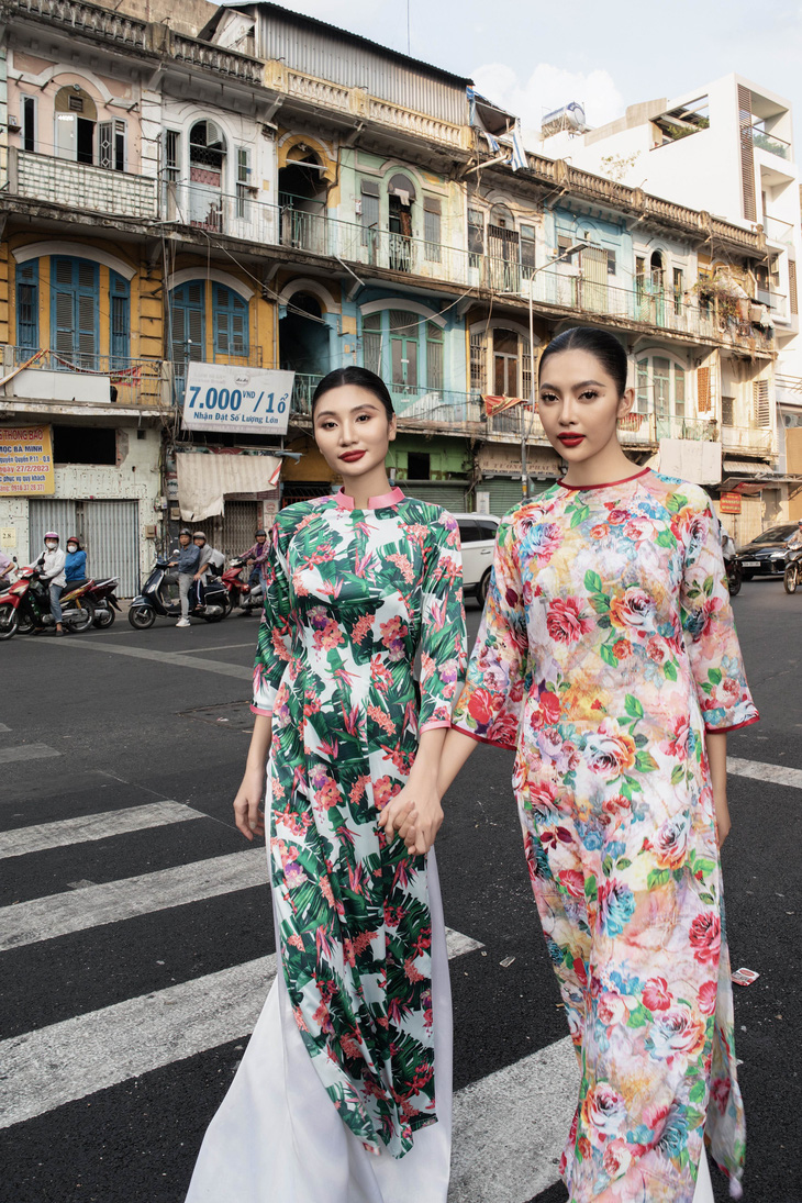 Hoa hậu Thu Uyên và á hậu Tuyết Nhi diện áo dài có họa tiết nổi bật ở một góc phố