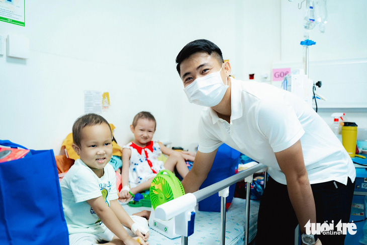 Cầu thủ đội bóng TP.HCM Ngô Tùng Quốc cùng đi trao quà cho các bệnh nhi tại Bệnh viện Nhi đồng TP.HCM - Ảnh: THANH HIỆP