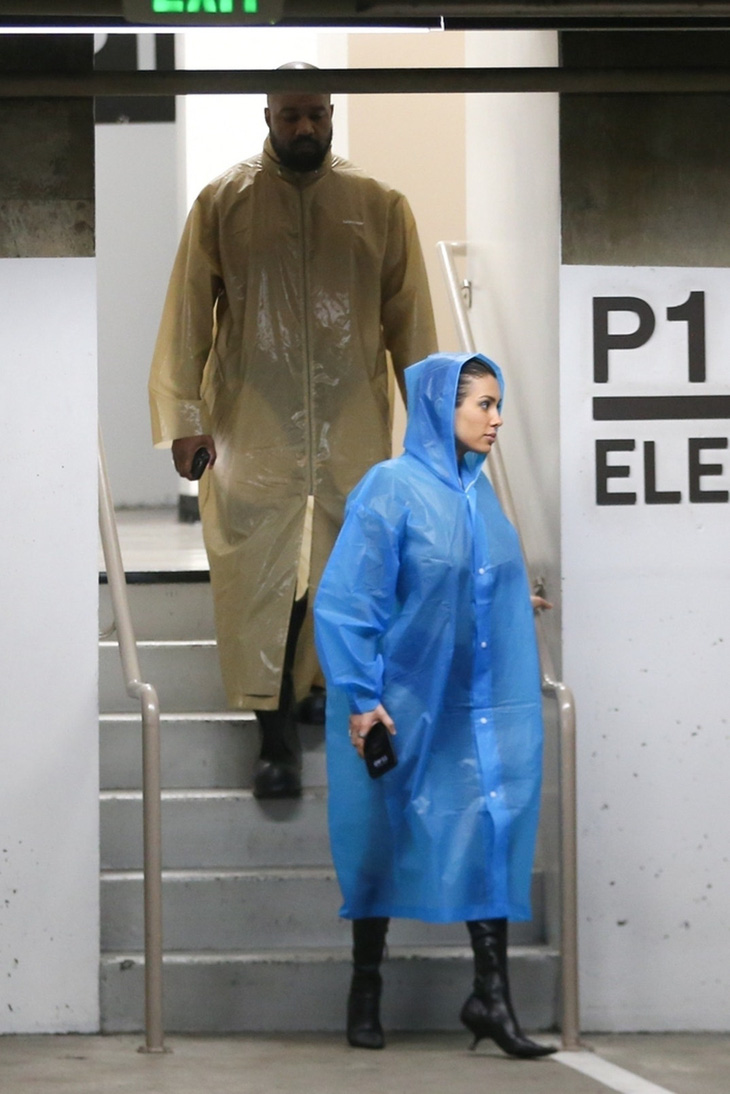 Kanye West và vợ mới bị bắt gặp đi ra từ trung tâm thương mại với trang phục áo mưa vào tiết trời khô ráo