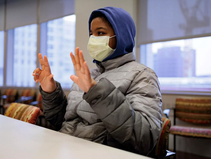 Aissam Dam, 11 tuổi, người đầu tiên được điều trị bằng liệu pháp gen ở Mỹ cho bệnh điếc bẩm sinh, ra hiệu cho thông dịch viên trong cuộc phỏng vấn vào ngày 16-1 tại Bệnh viện Nhi đồng Philadelphia. Ảnh: nytimes.com