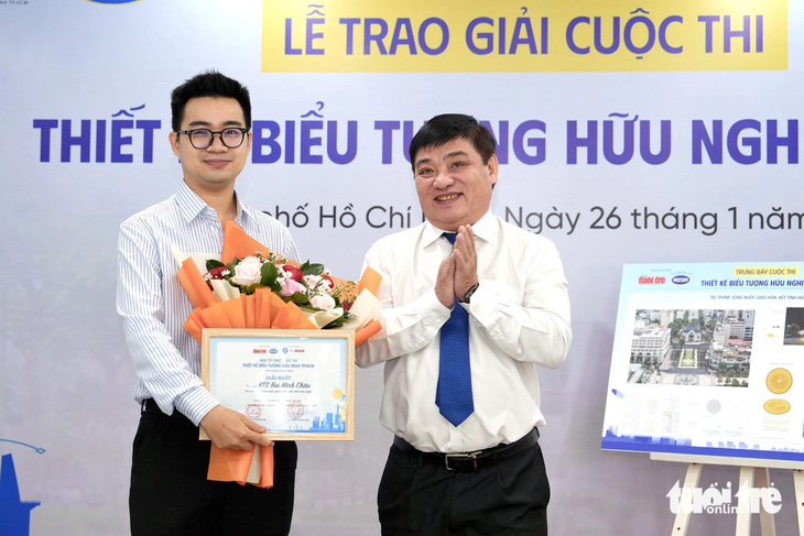 Nhà báo Lê Thế Chữ, tổng biên tập báo Tuổi Trẻ, trao giải cho tác giả đoạt giải nhất - kiến trúc sư Bùi Minh Châu - Ảnh: HỮU HẠNH